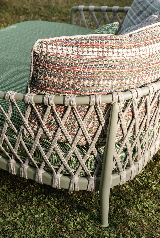 B&B Italia Erica 19 Outdoor Lounge in grün und beige auf einer Wiese Mood Bild von hinten mit Kissen und geflochtenem Rahmen