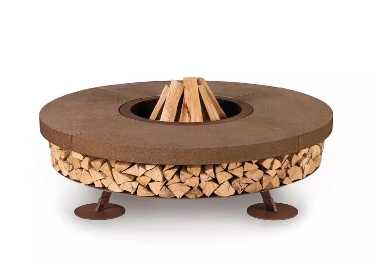 AK47 Ercole Small Stahl Feuerstelle 150 cm Beton Braun mit Holzstapeln darunter ohne Hintergrund