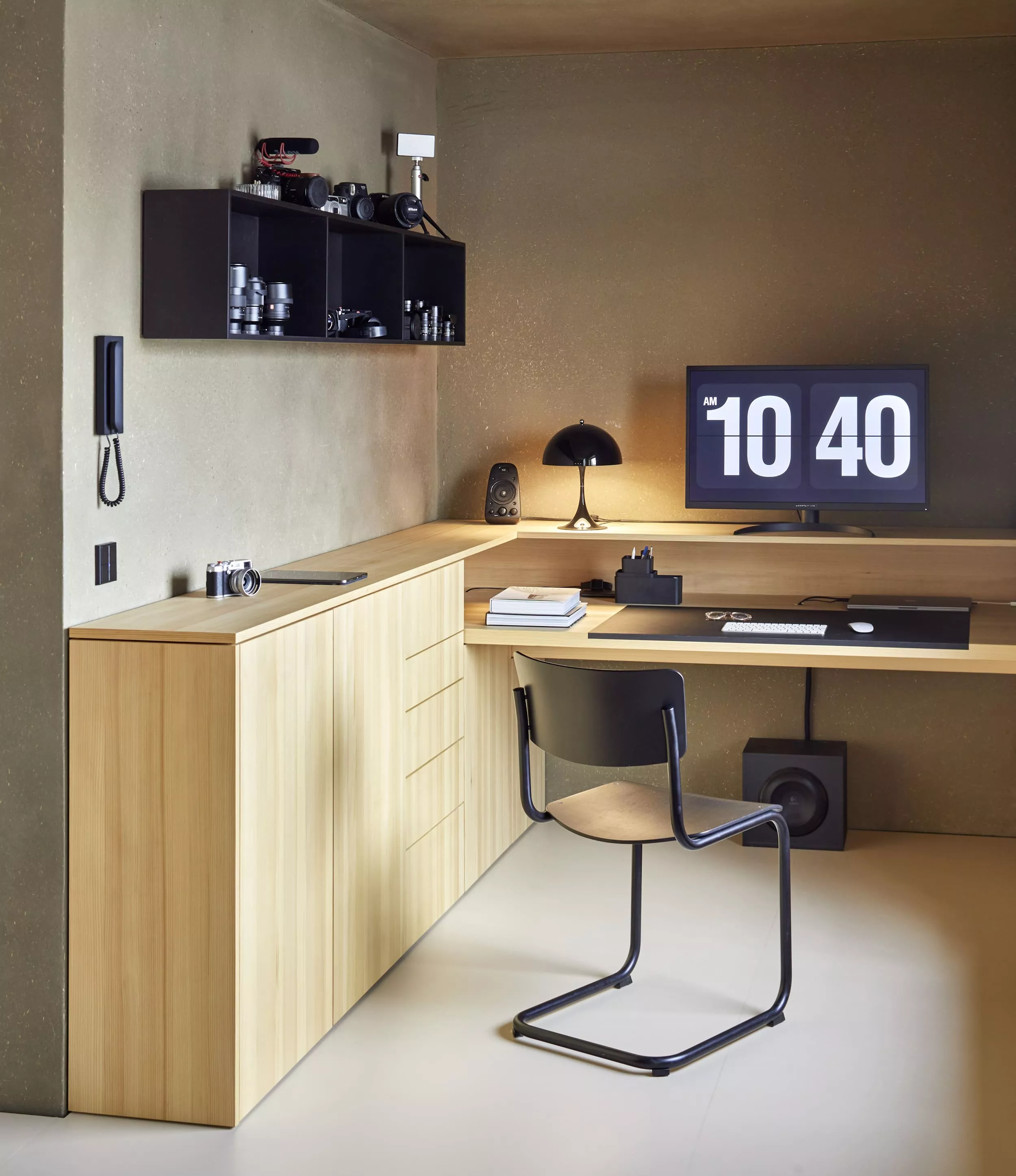 Ein modernes Büro mit einem Thonet S43 Stuhl einem Schreibtisch mit Computer und Regalen an der Wand im minimalistischen Design.