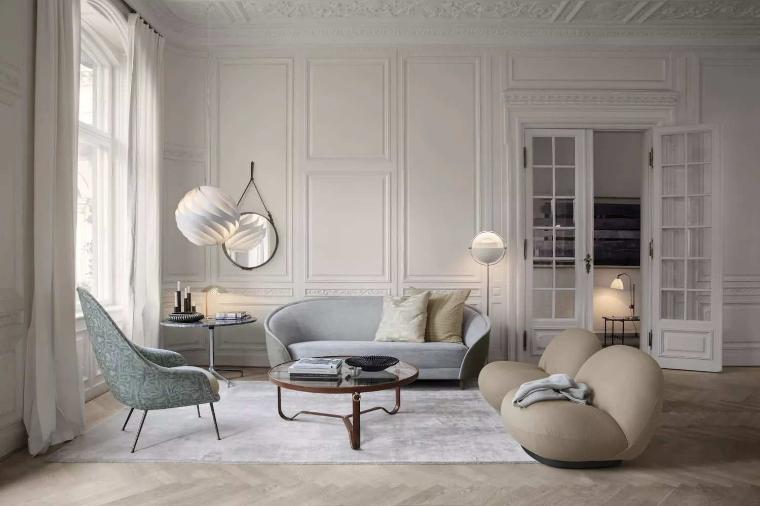 Elegantes Wohnzimmer mit grauem Revers Sofa, beigem Pacha Chair, Bat Chair in Blau, Beetle Table und Multi-Lite Lampen auf hellem Holzboden.