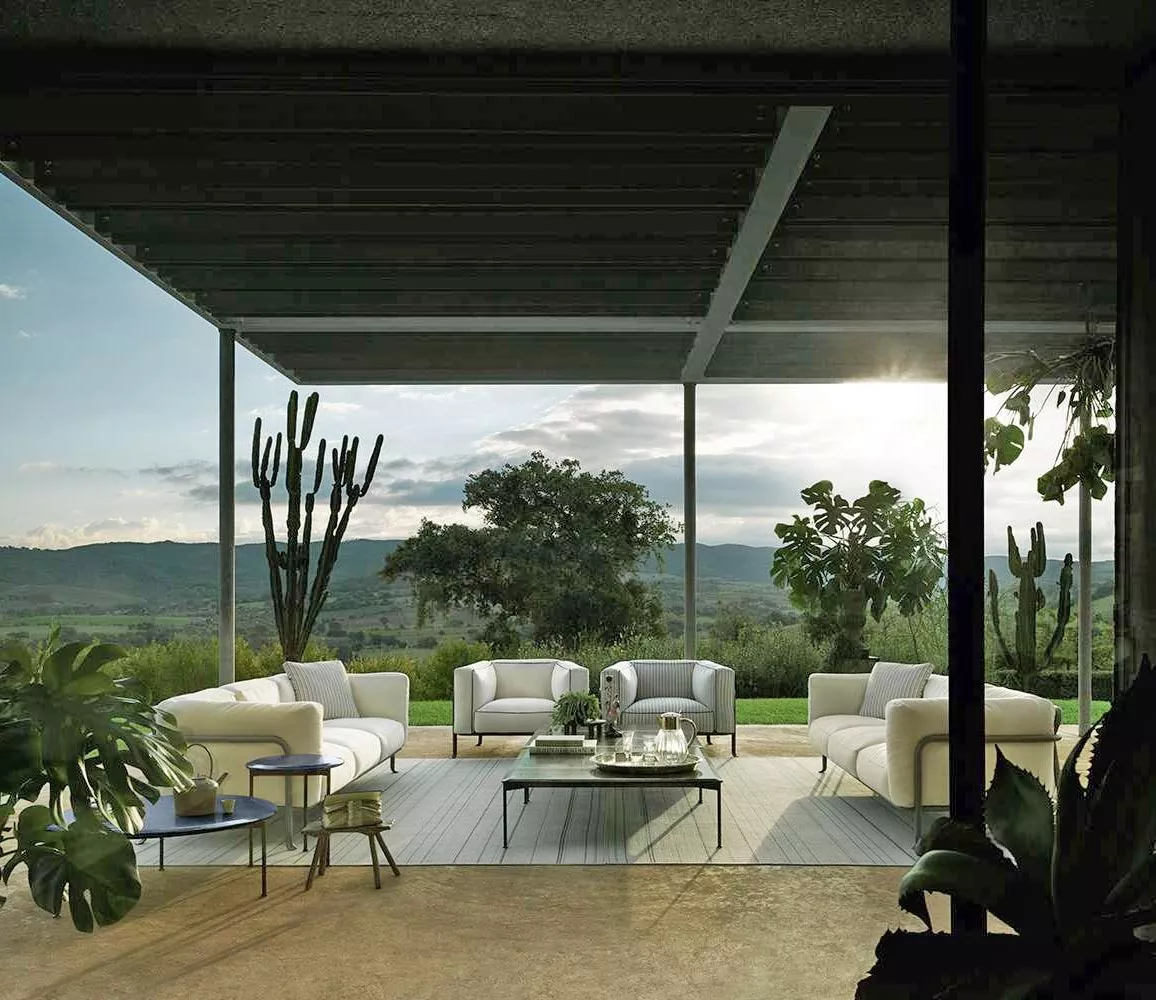 B&B Italia Borea Loungesofa und Outdoor Loungegruppe auf einer Terrasse mit Blick auf die Natur und umgeben von Pflanzen bei Sonnenuntergang