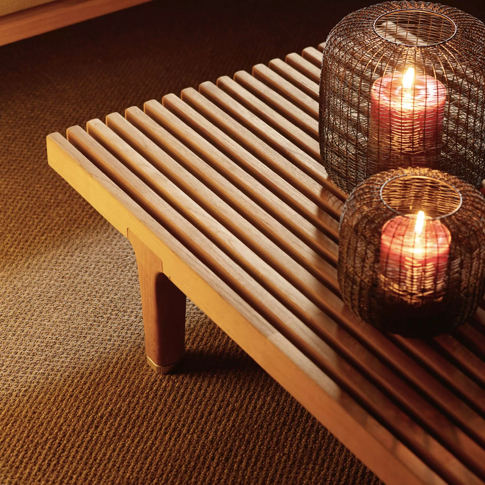 Dedon Sealine Loungetisch aus Holz mit zwei dekorativen Kerzenhaltern auf einem Teppich in einer gemütlichen Atmosphäre