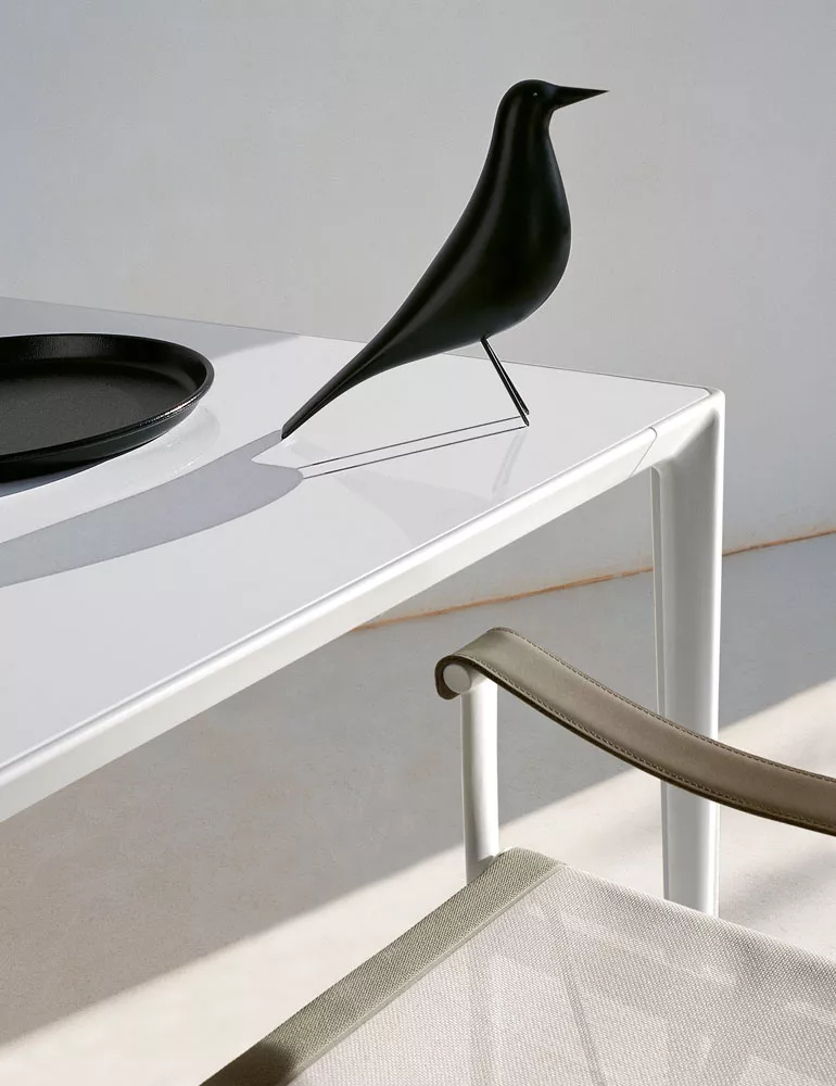 B&B Italia Mirto Outdoor Esstisch in Weiß mit schwarzer Dekofigur und beigem Stuhl in einem minimalistischen Ambiente