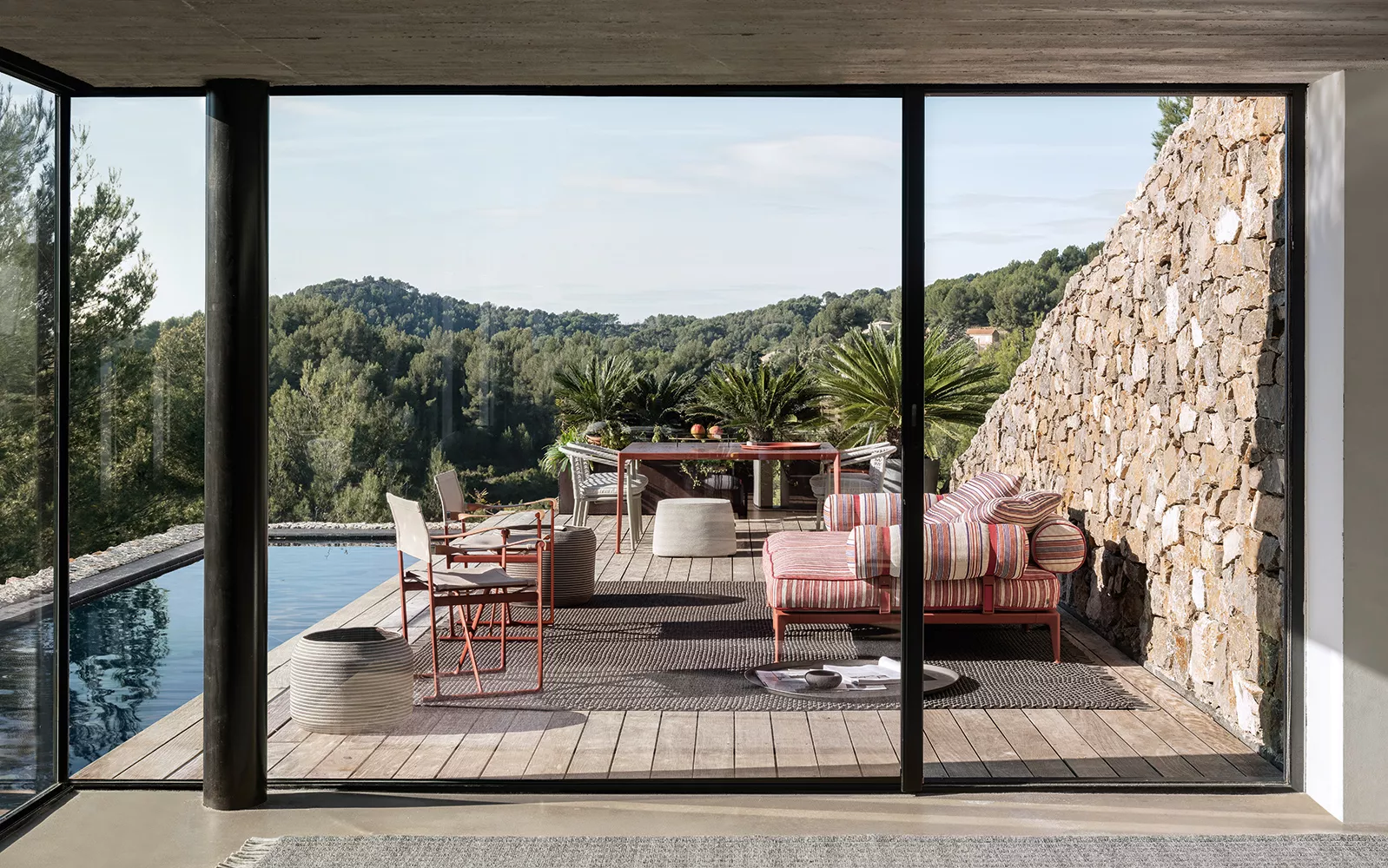 B&B Italia Ribes Outdoor Lounge auf einer Terrasse mit Blick auf die Natur und einem Pool im Hintergrund 