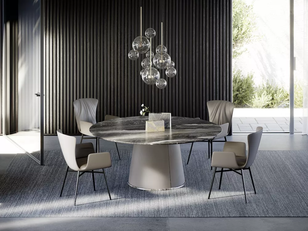 Runder Esstisch Dexter 2058 in Marmoroptik mit grauen Stühlen, in modernem Raum mit Glasleuchter und Holzvertäfelung im Hintergrund.