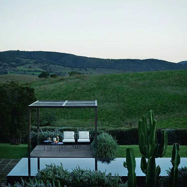 B&B Italia Borea Loungesofa und Tisch auf einer Terrasse mit Blick auf eine grüne Landschaft und Hügel im Hintergrund 
