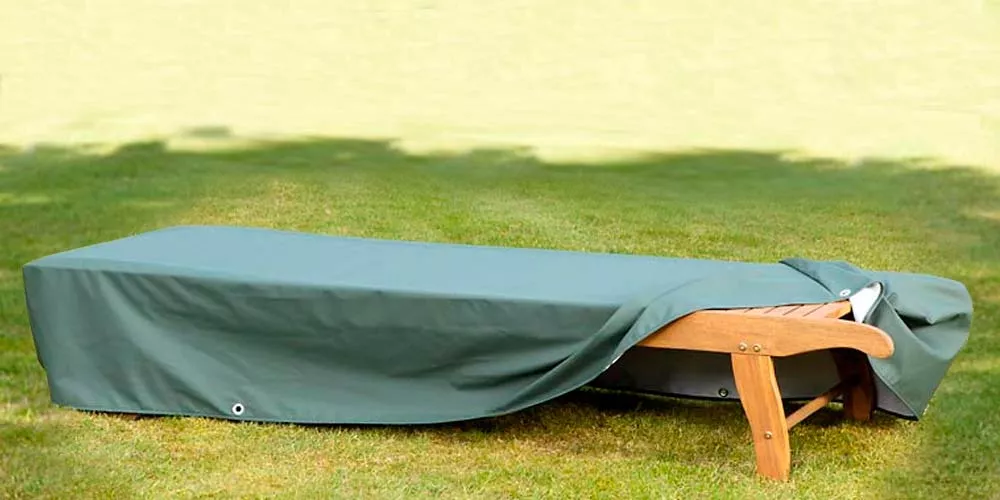 Grüne Liegenhaube von Villa Schmidt auf einer Holzliege im Garten, wetterfest und schützend, in entspannter Sommeratmosphäre.