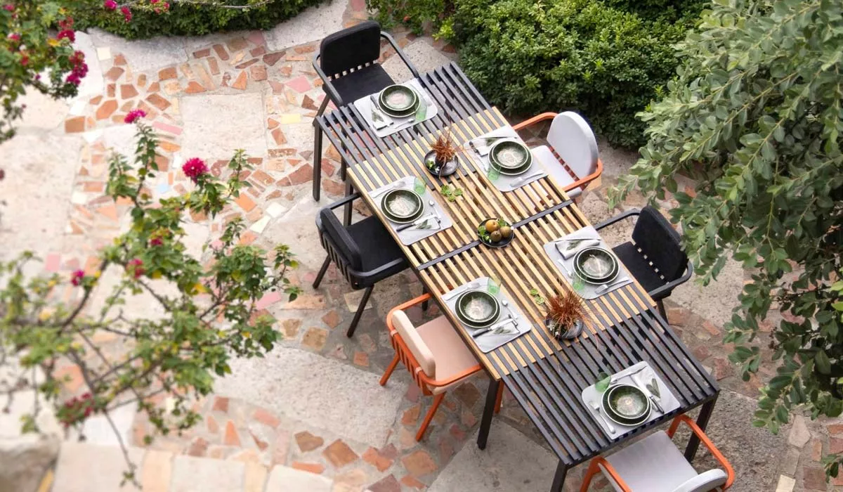 EGO Paris Kama Essgruppe in Schwarz und Orange auf einer Terrasse mit Steinboden, aus der Vogelperspektive fotografiert.