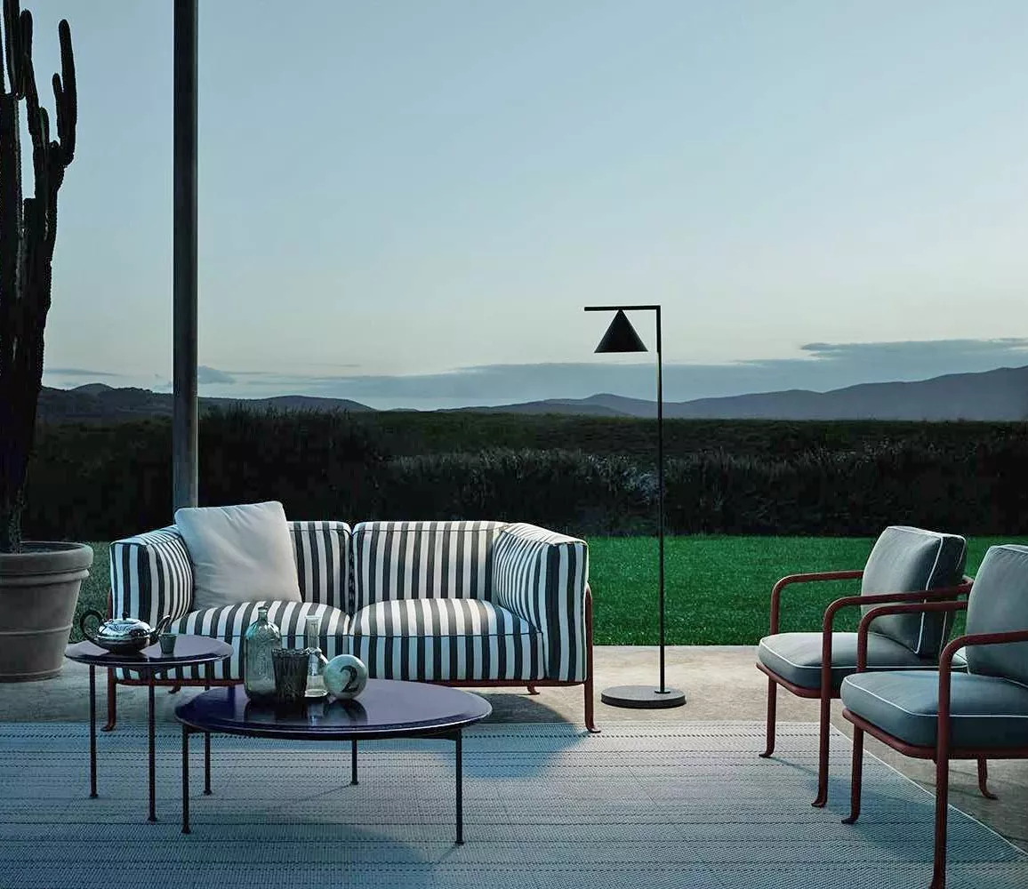 B&B Italia Borea Loungesofa und Outdoor Loungegruppe auf einer Terrasse mit Blick auf eine grüne Wiese und Berge im Hintergrund stimmungsvolles Bild