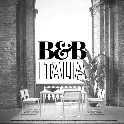 Schwarz-weißes Stimmungsbild mit B&B Italia Möbeln in einem historischen Innenhof mit Pflanzen und Backsteinwänden.