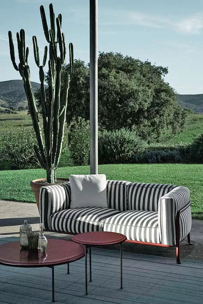B&B Italia Borea Loungesofa steht auf einer Terrasse mit Blick auf einen Garten mit Kakteen und Bäumen im Hintergrund