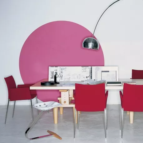 Zanotta Lia Armlehnstuhl in Rot, um einen Tisch in einem modernen Raum mit weißem Boden und pinker Wanddekoration arrangiert.