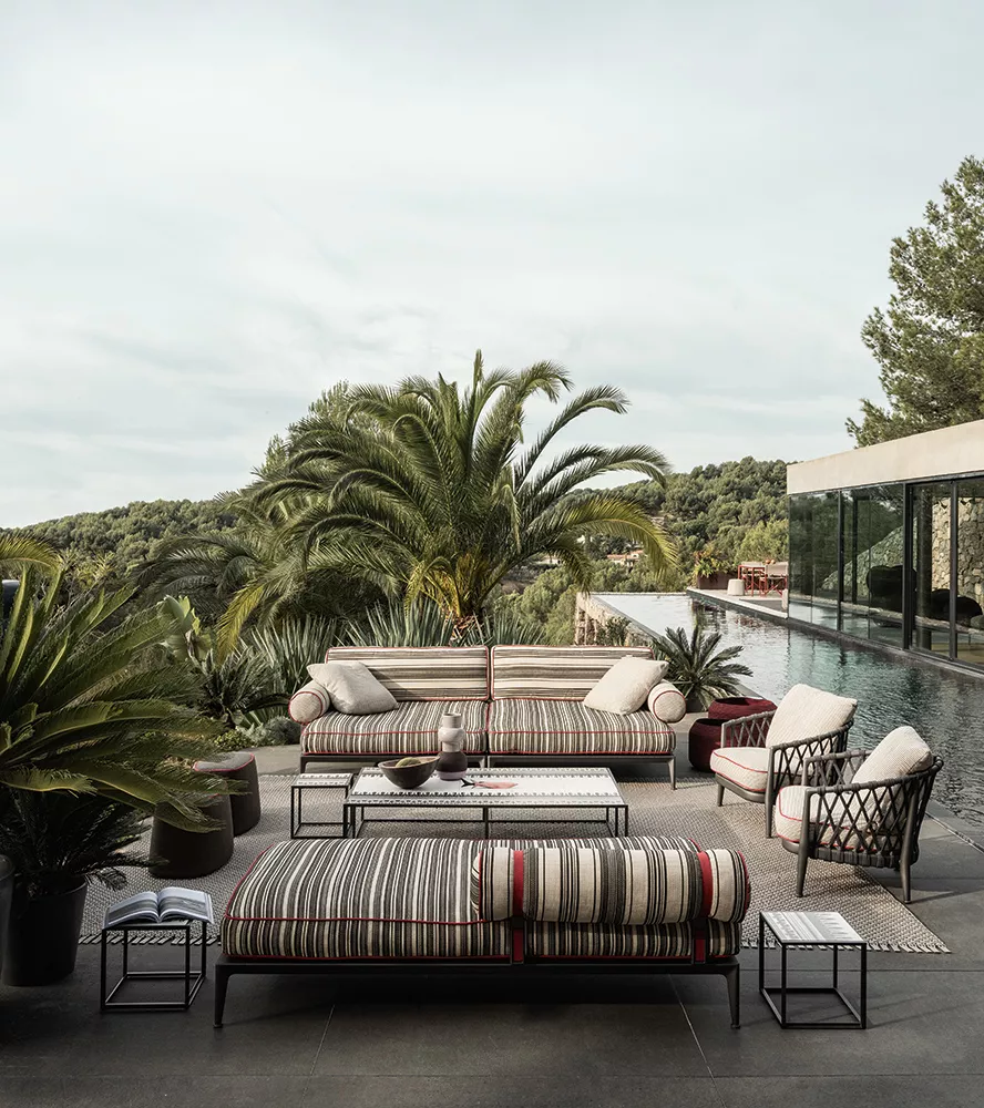 B&B Italia Ribes Outdoor Lounge auf einer Terrasse mit Pool und Palmen im Hintergrund 