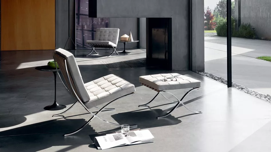 Mies Van Der Rohe Barcelona Chair in Weiß, modernes Wohnzimmer, Betonboden, Tageslicht, stilvolle Einrichtung.